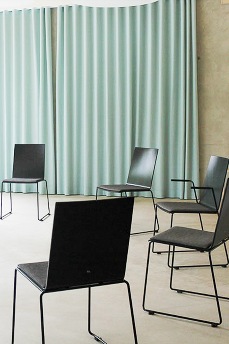 Stuhlkreis Seminarraum 8 A circle of chairs in a training room with green curtains