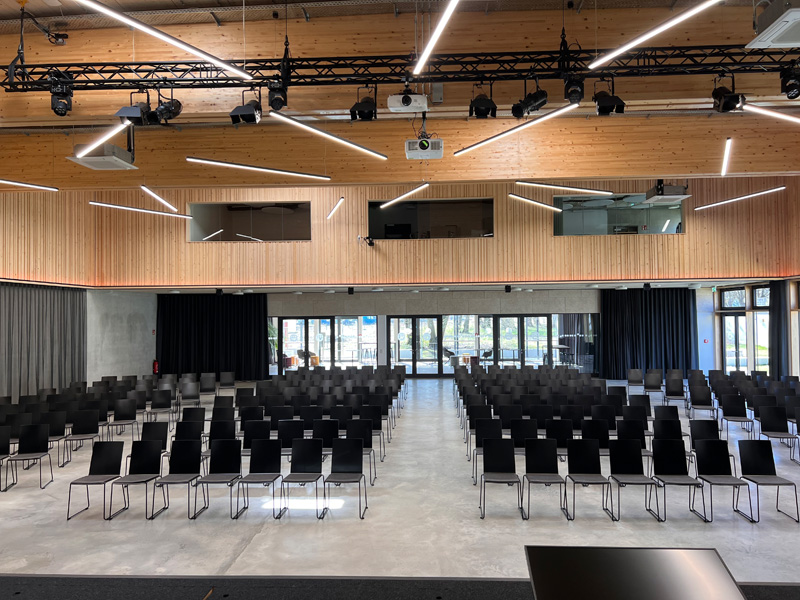 Saal Bühnenperspektive Saal zum Mieten mit schwarzen Stühlen