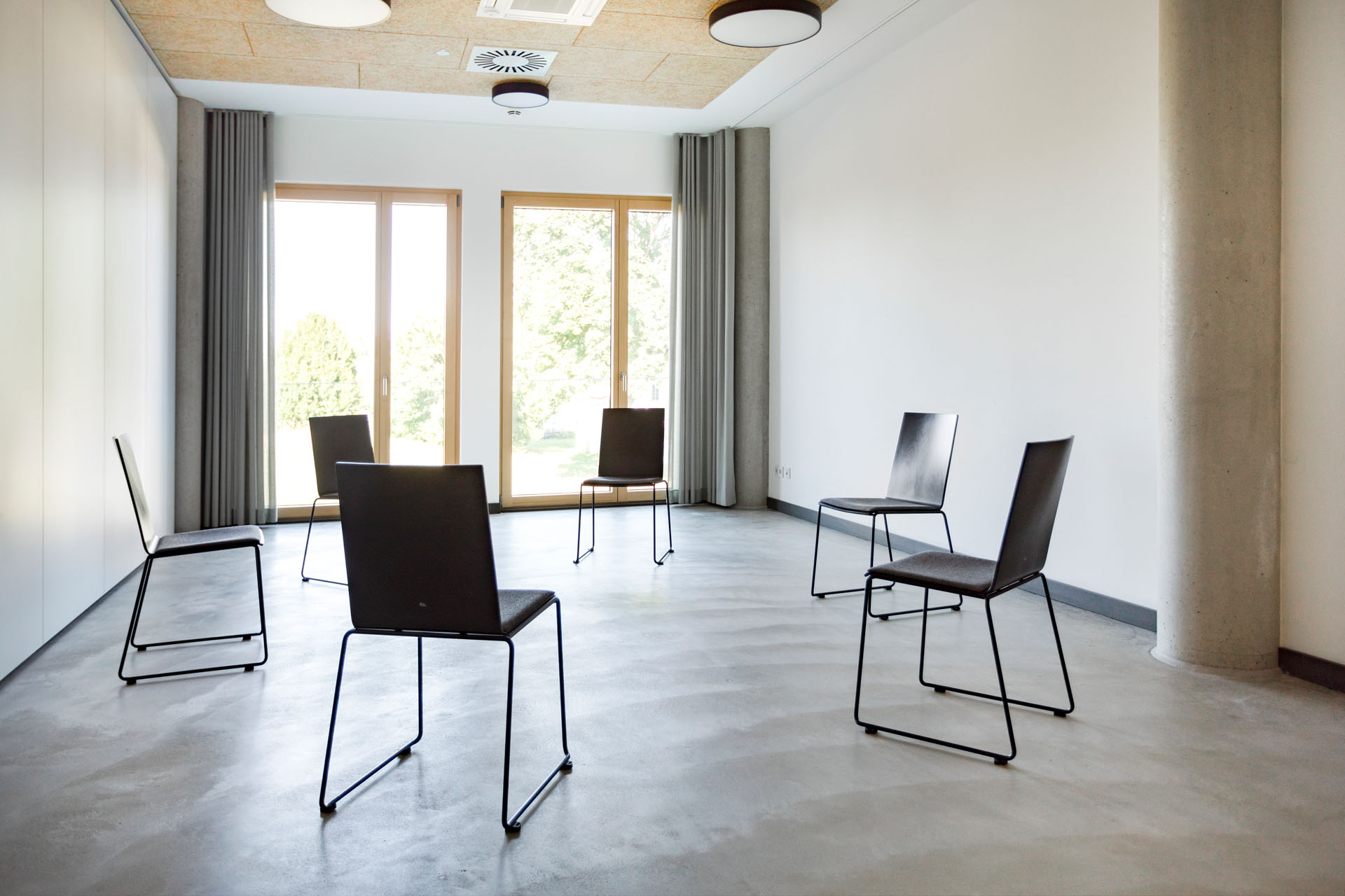 Gruppenraum „Georg“ Group room with six black chairs in front of large windows