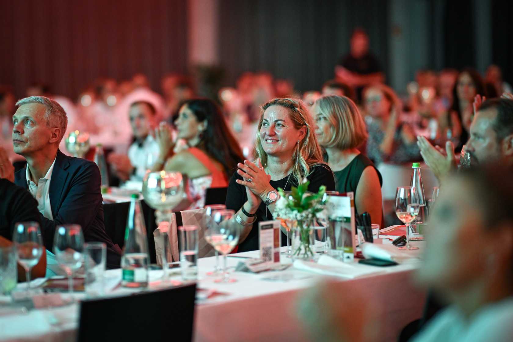 Lächelnde Frau bei einer Spendengala bzw. Konferenz im westhouse in einem großem Publikum