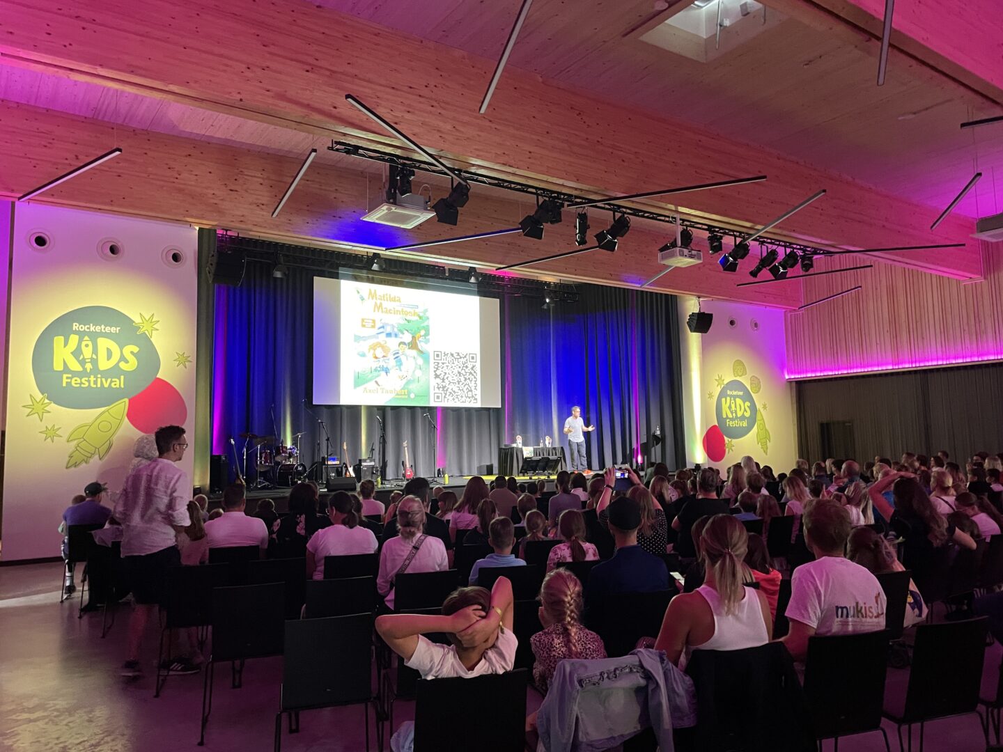 Veranstaltungssaal mit Kindern vor der Bühne bei einem Festival